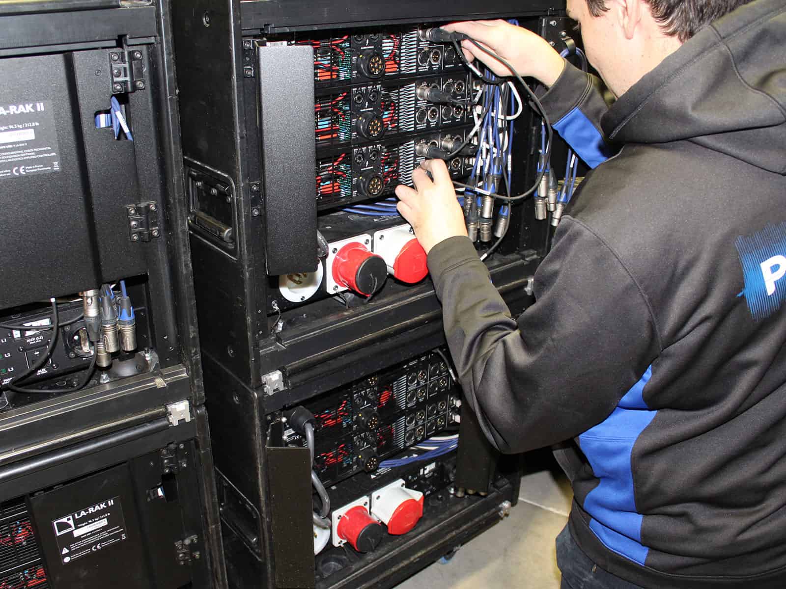 Technician patching amplifier rack